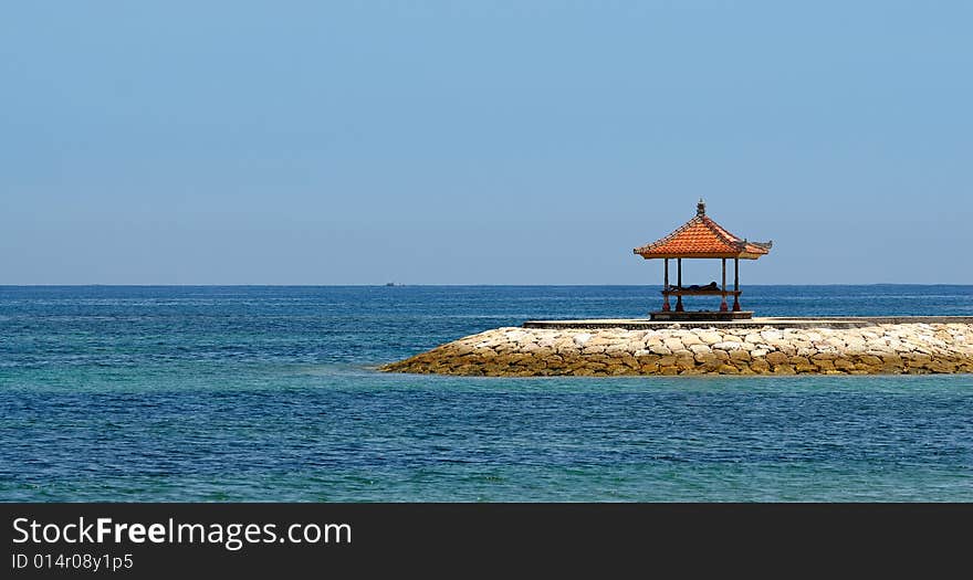 Sea view from the beach with a person relaxing in the shelter. Sea view from the beach with a person relaxing in the shelter