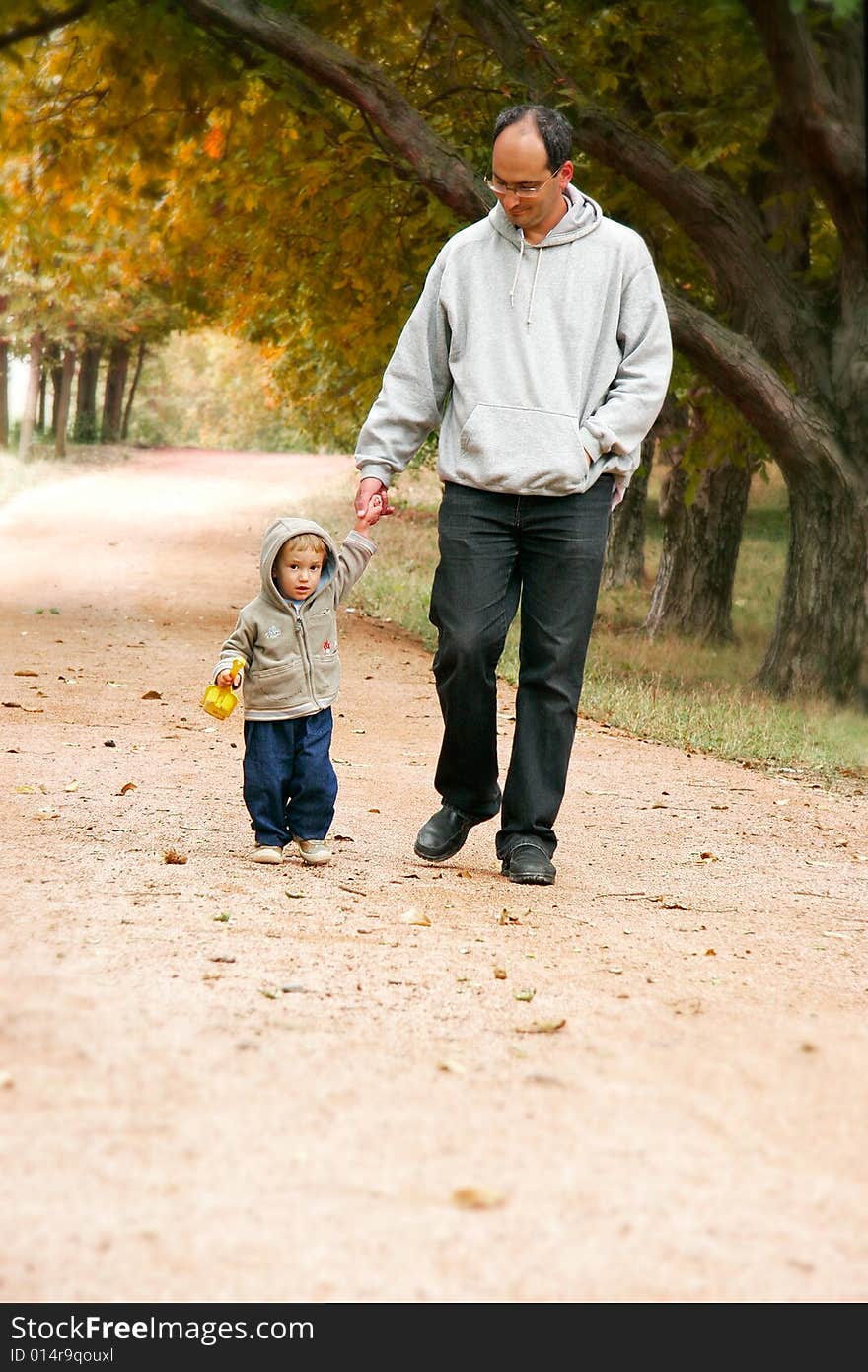 Father and son walking in park. Father and son walking in park