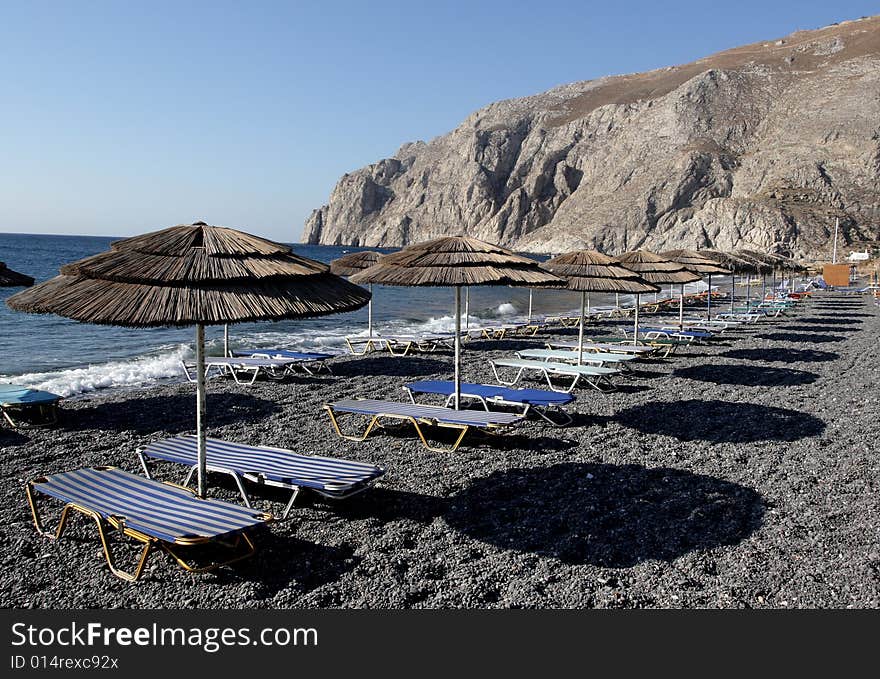 Beach umbrellas on Kamari beach in the morning