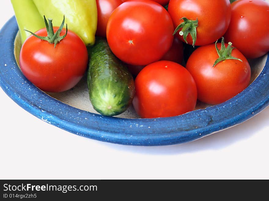 Fresh tomato, sweet peper  and cucumber on country style plate isolated on white background. Fresh tomato, sweet peper  and cucumber on country style plate isolated on white background