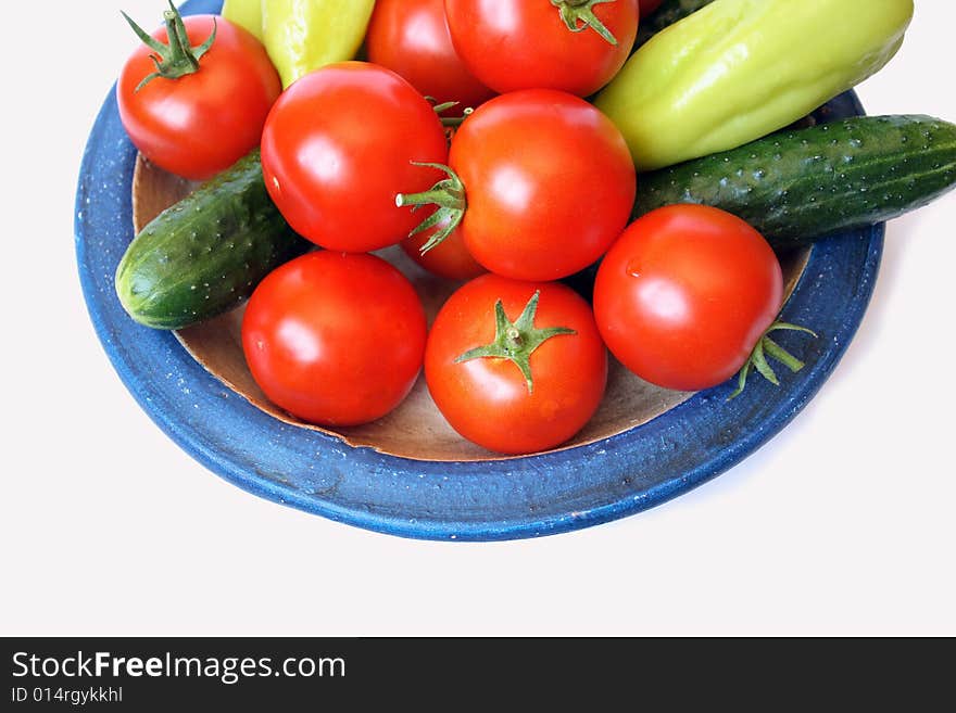 Fresh tomato, sweet peper  and cucumber on country style plate isolated on white background. Fresh tomato, sweet peper  and cucumber on country style plate isolated on white background