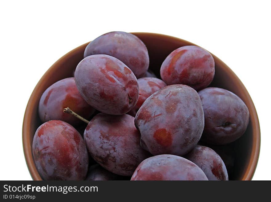 Plums on plate isolated on white background