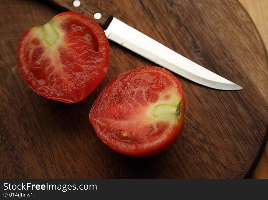 Fresh Tomato With Knife On Kitchen Board