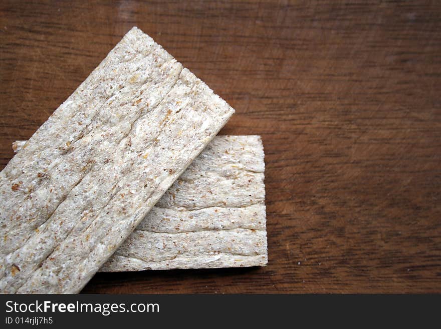 Crackers in brown bowl on wooden table. Crackers in brown bowl on wooden table