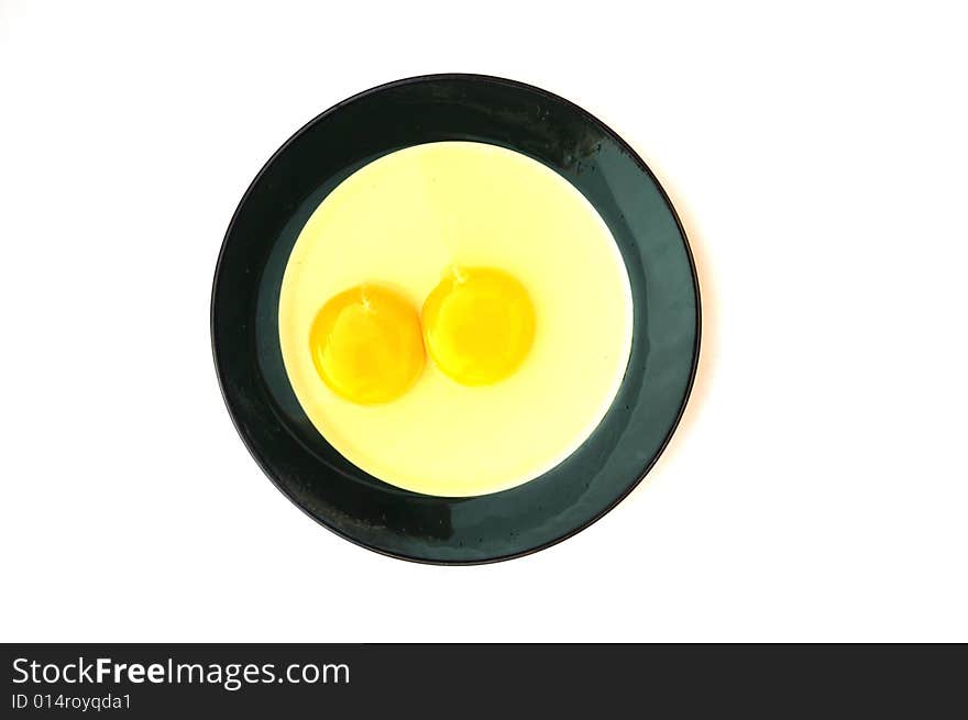 Two crashed eggs in the  plate.