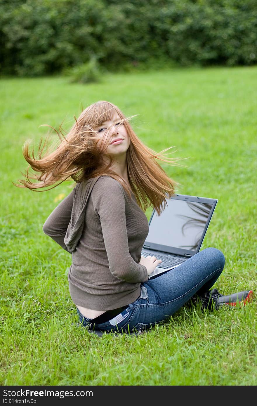 Young girl sitting on the grass.