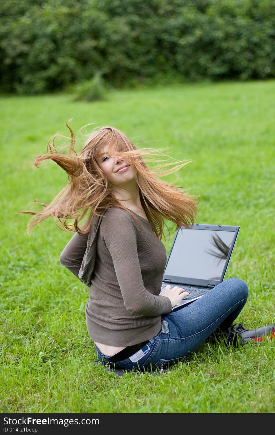 Young girl sitting on the grass.