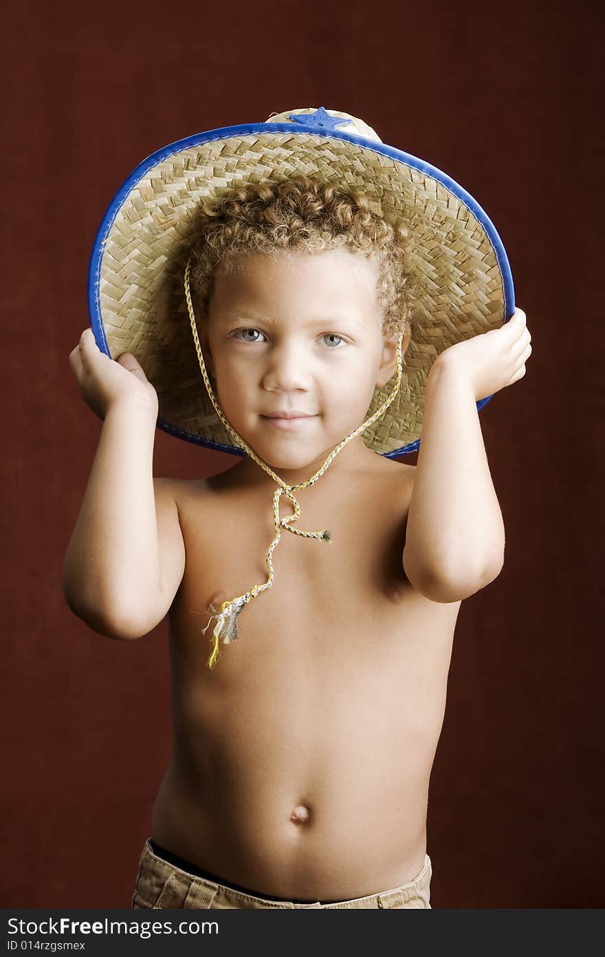 Little boy with curly hair and blue eyes in a sheriff hat. Little boy with curly hair and blue eyes in a sheriff hat