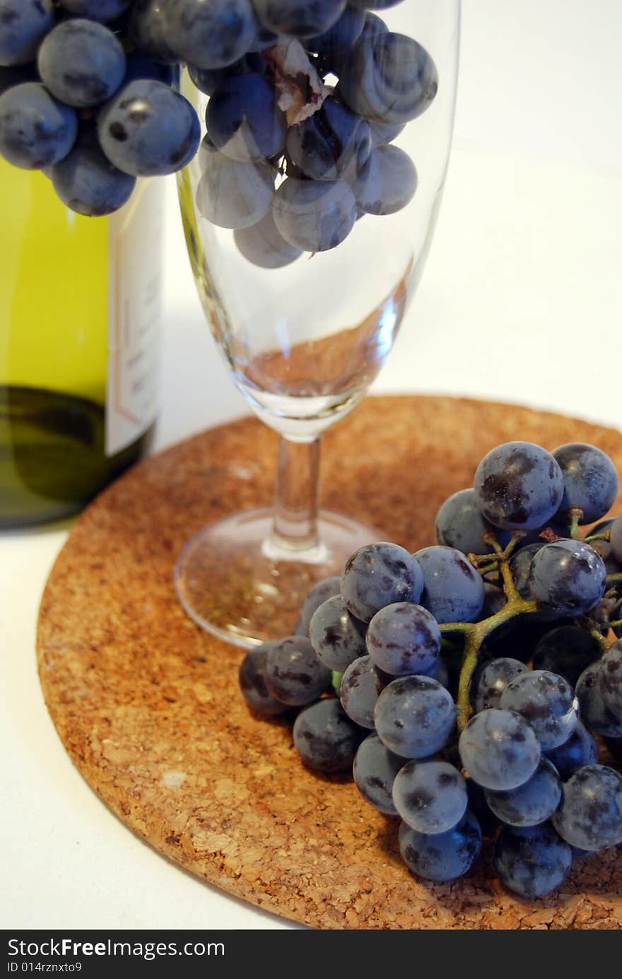 Black grapes in a glass isolated on white background. sweet wine grapes in a glass and a bottle on white background.