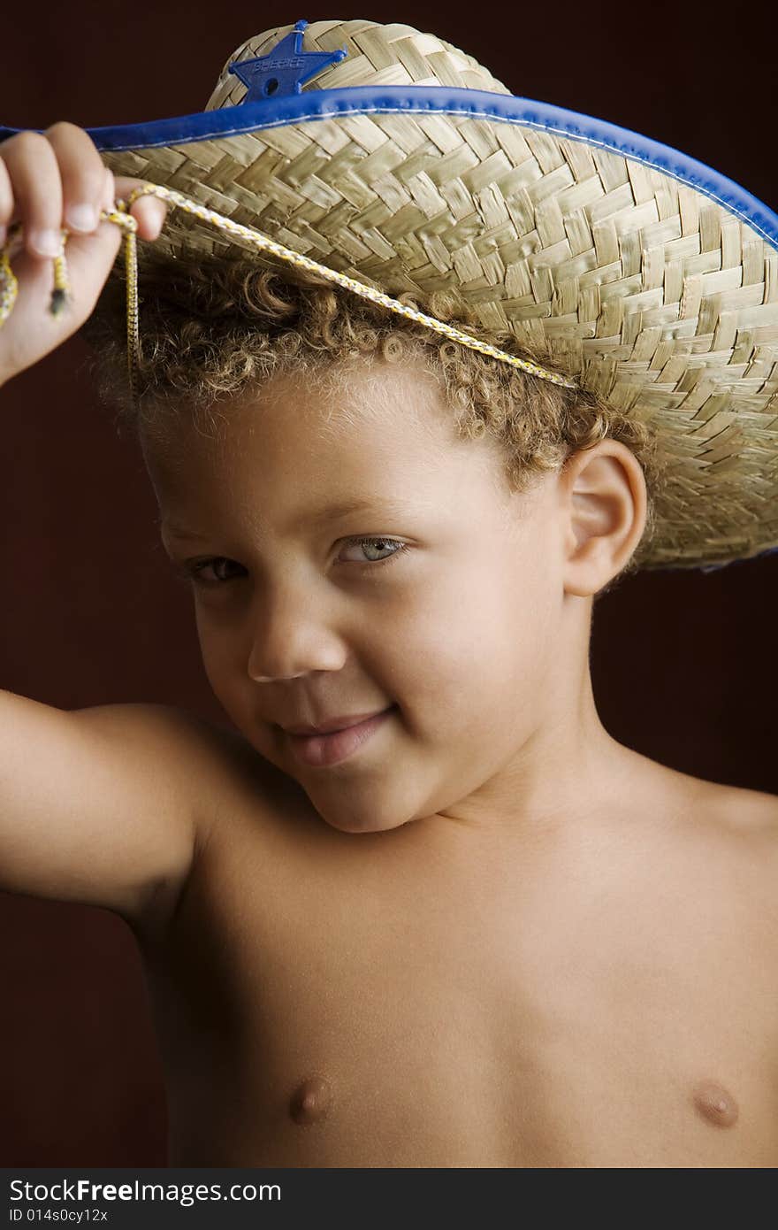 Little boy with curly hair and blue eyes in a sheriff hat. Little boy with curly hair and blue eyes in a sheriff hat