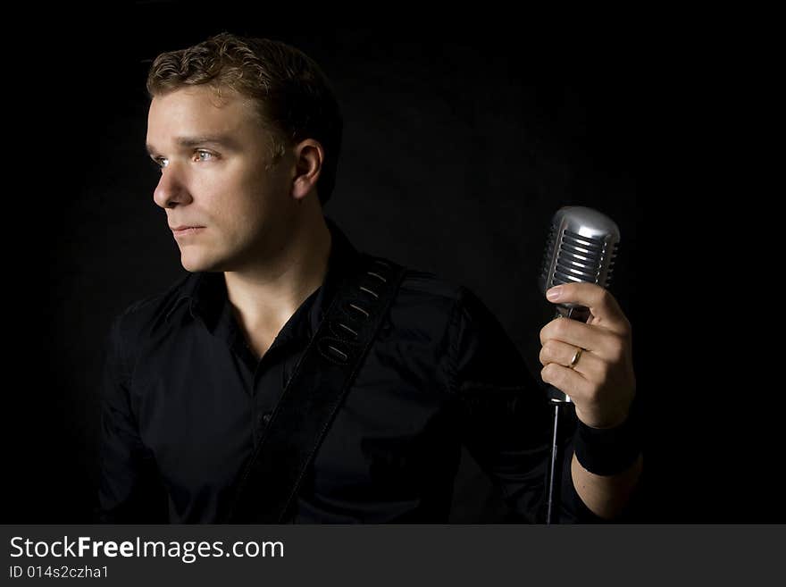 Portrait of young musician holding his microphone