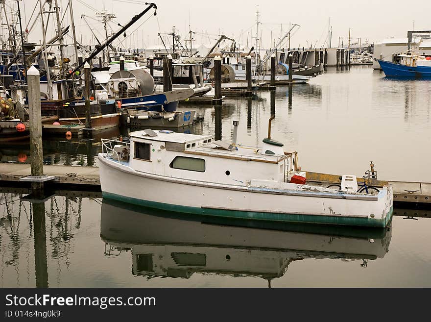 An old green and white fishing boat at a harbor