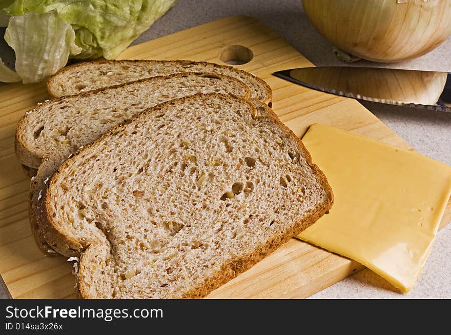 A sandwich is readied on the cutting board. A sandwich is readied on the cutting board.