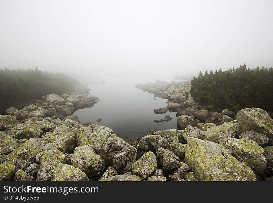 Mountain lake covered in mist in Polish Tatra