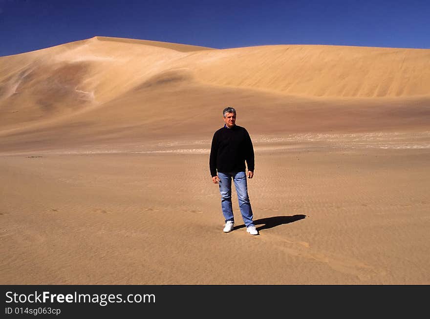 A view of the nature in the desert of namibia, a man walking in the pure desert. A view of the nature in the desert of namibia, a man walking in the pure desert