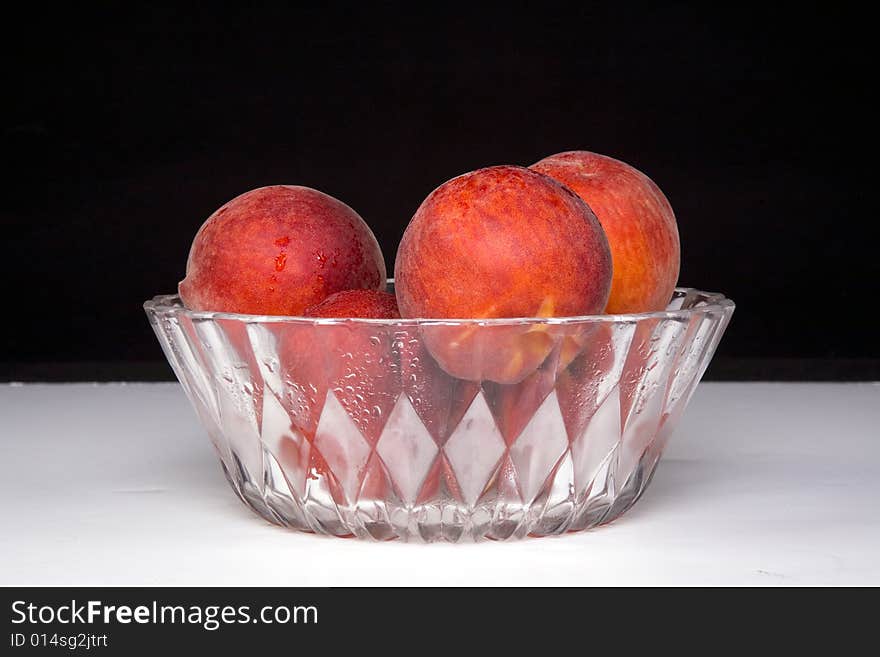 Shot of a freshly washed bowl of peaches in a crystal bowl.