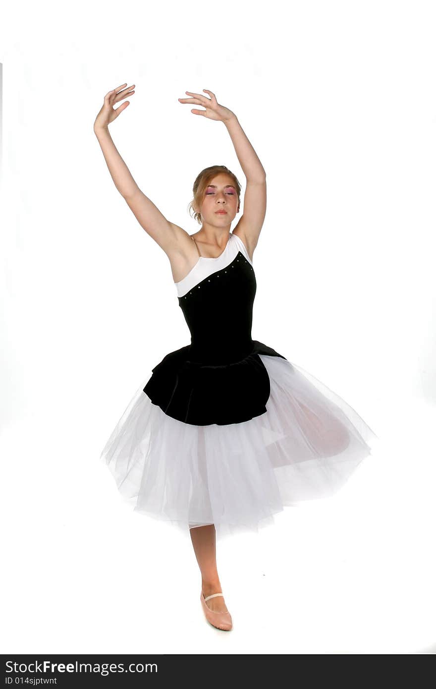 Ballerina girl with her arms up and eyes closed in concentration while standing on one foot. Ballerina girl with her arms up and eyes closed in concentration while standing on one foot