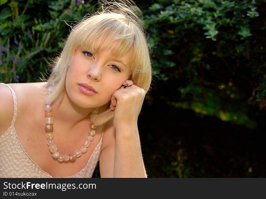 Close portrait of relaxed attractive blond girl in garden