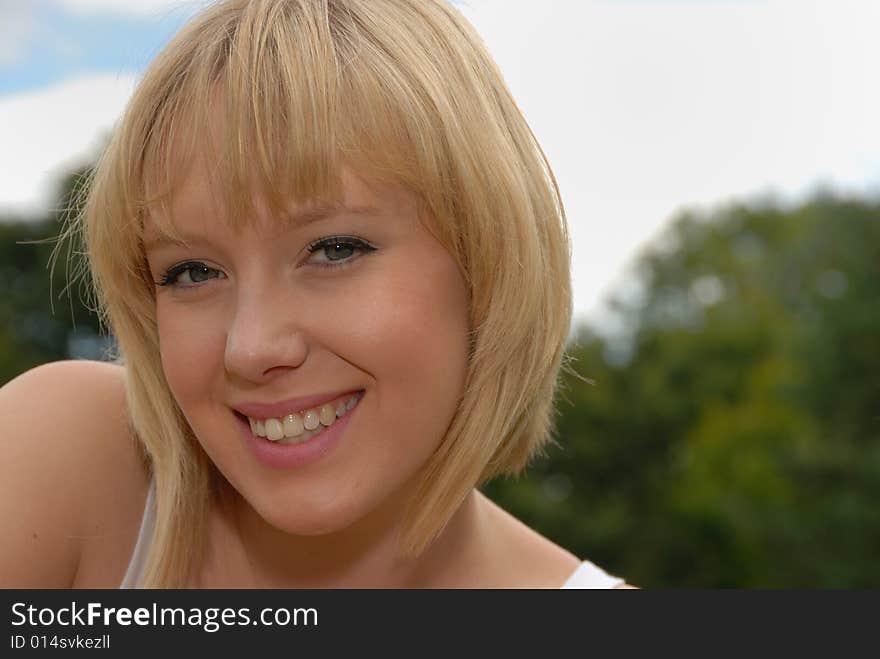 Close portrait of attractive blond girl in garden. Close portrait of attractive blond girl in garden