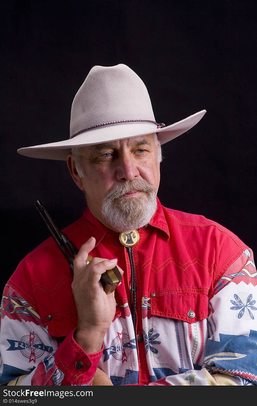 Shot of an older western man with a string tie and white hat.