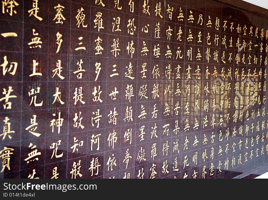 Chinese characters in red written on stone background