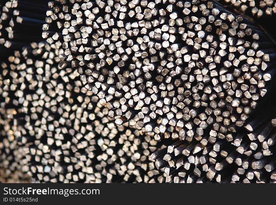 Macro of a tied bundle of cold steel bars on construction site. Macro of a tied bundle of cold steel bars on construction site