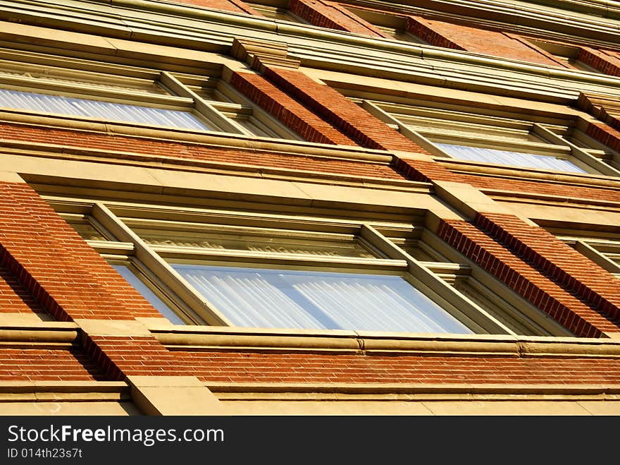 Angled shot of a red-brick wall with windows in Denver Colorado.