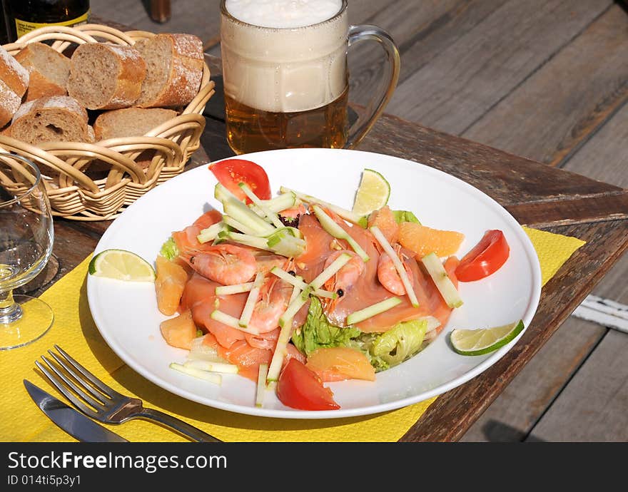 Dinner on terrace with seafood salad and beer