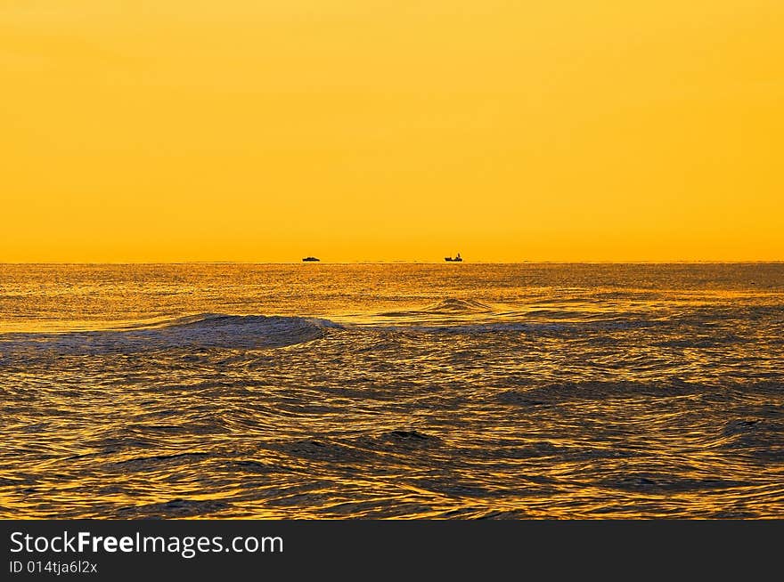 Seascape in the morning yellow lights. Two ships on horizon. Seascape in the morning yellow lights. Two ships on horizon.