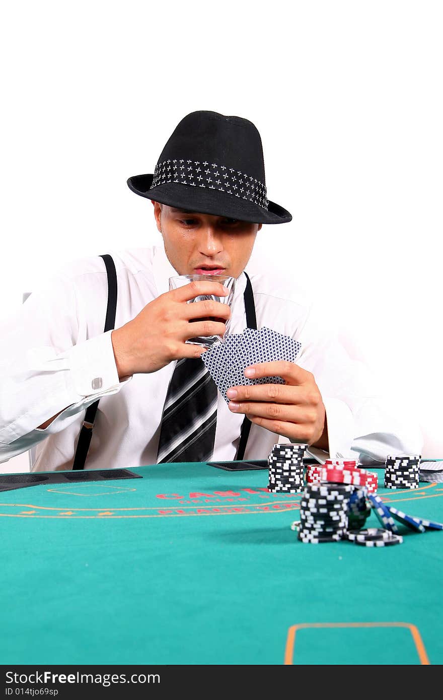 Young man playing poker with a hat and stylish suit. Isolated over white background.