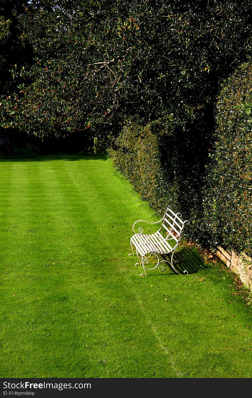 A garden bench in a peaceful spot in the garden. A garden bench in a peaceful spot in the garden