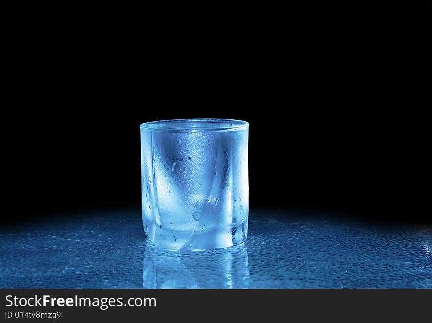 Glass of cold water standing on dark background. Glass of cold water standing on dark background