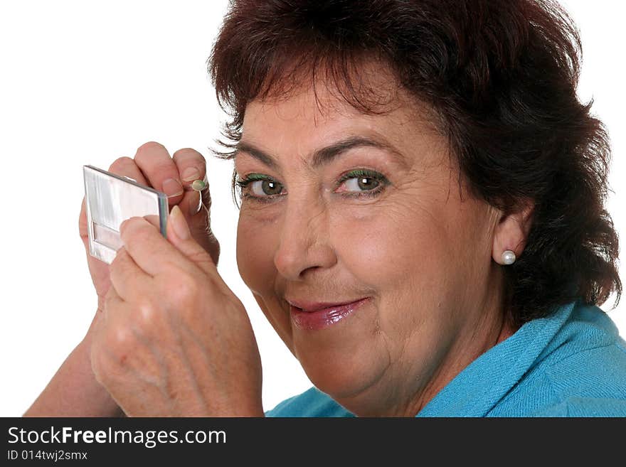 Middle-aged woman applying make up