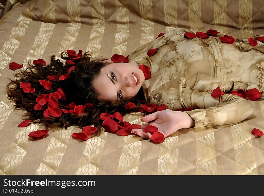 Beautiful smiling woman with red rose petals. Beautiful smiling woman with red rose petals