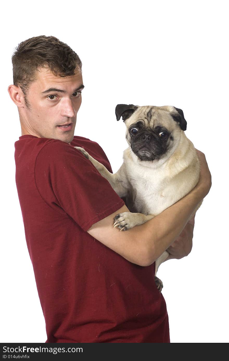 A man holds a scared looking pug dog in his arms. A man holds a scared looking pug dog in his arms