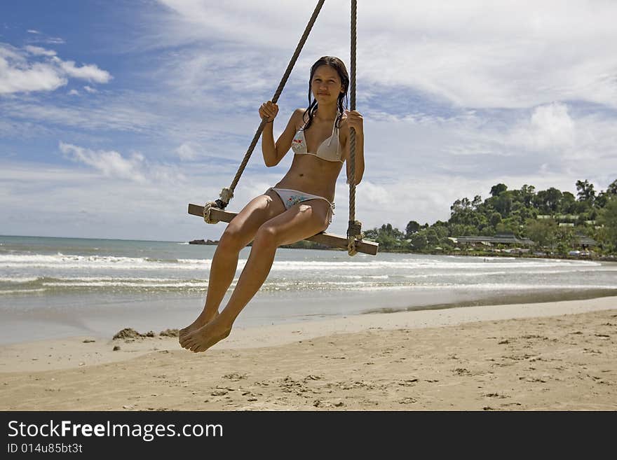 Girl on swing on the beach