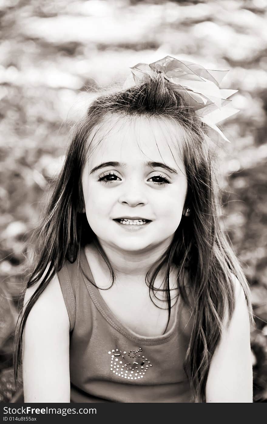 Beautiful little girl with a big pink bow in her hair. She has a beautiful smile with perfect baby teeth. Beautiful little girl with a big pink bow in her hair. She has a beautiful smile with perfect baby teeth.