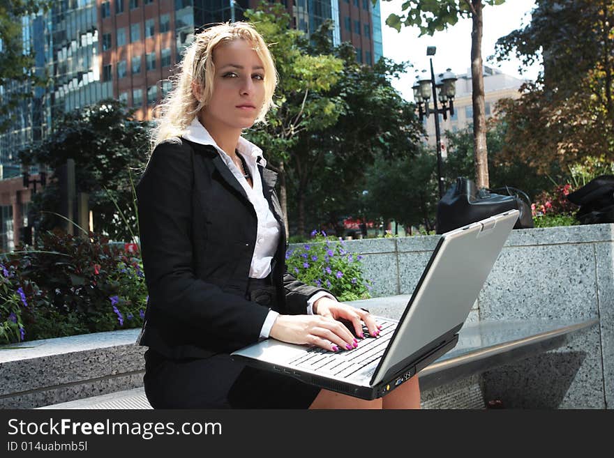 Pretty women sitting outside with a lap top cumputer. Pretty women sitting outside with a lap top cumputer