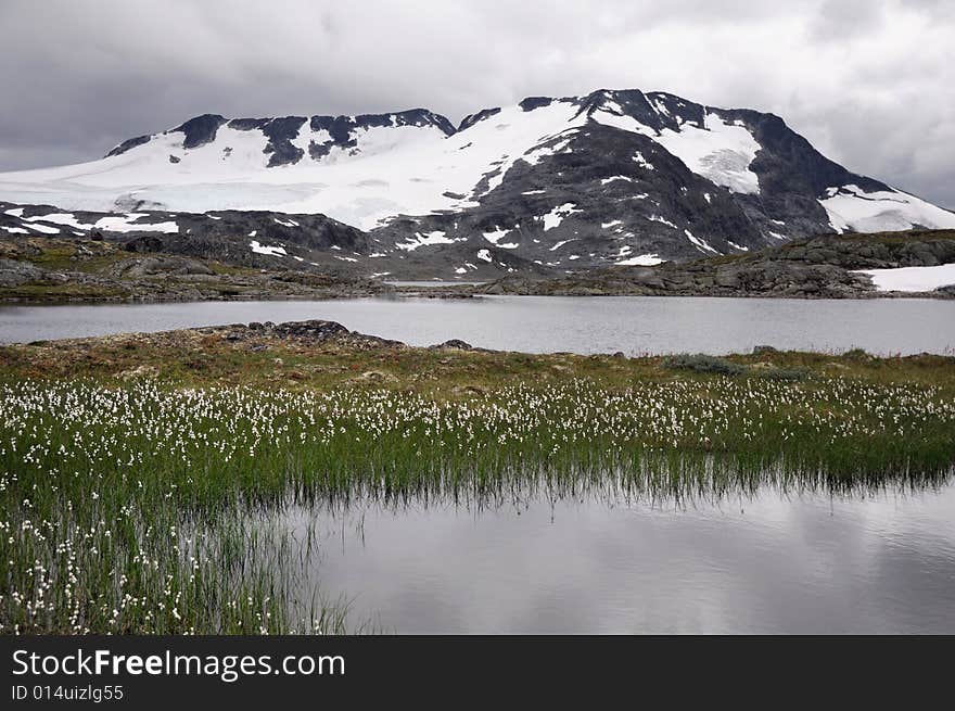 Landscape with glacial lake and mountain peak.