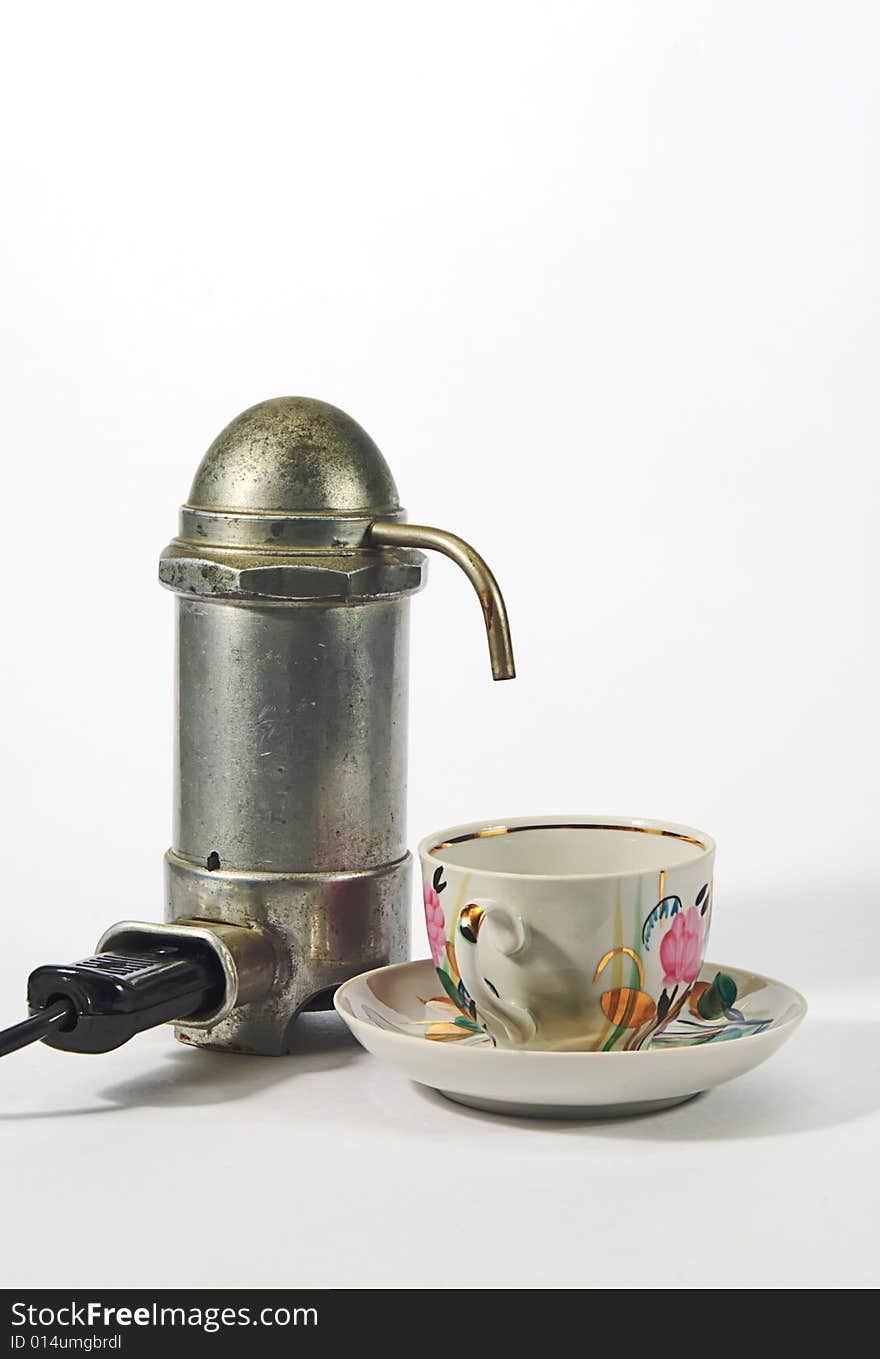 Old aluminium electrical  coffee machine  and cup. Old aluminium electrical  coffee machine  and cup