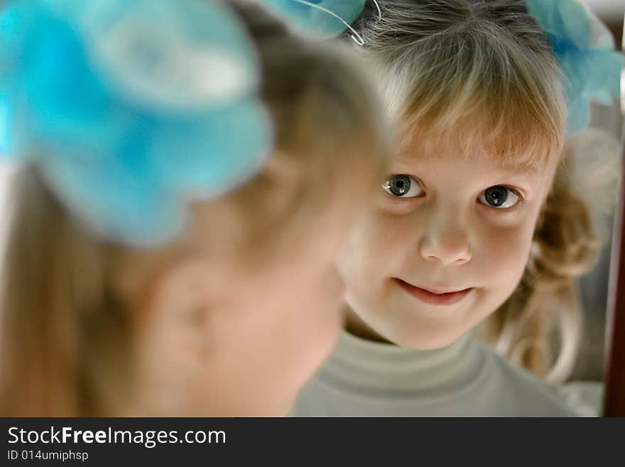 The little girl looks in the mirror. The little girl looks in the mirror