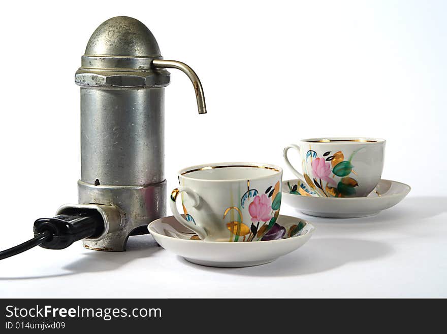 Old aluminium electrical  coffee machine  and two cups. Old aluminium electrical  coffee machine  and two cups