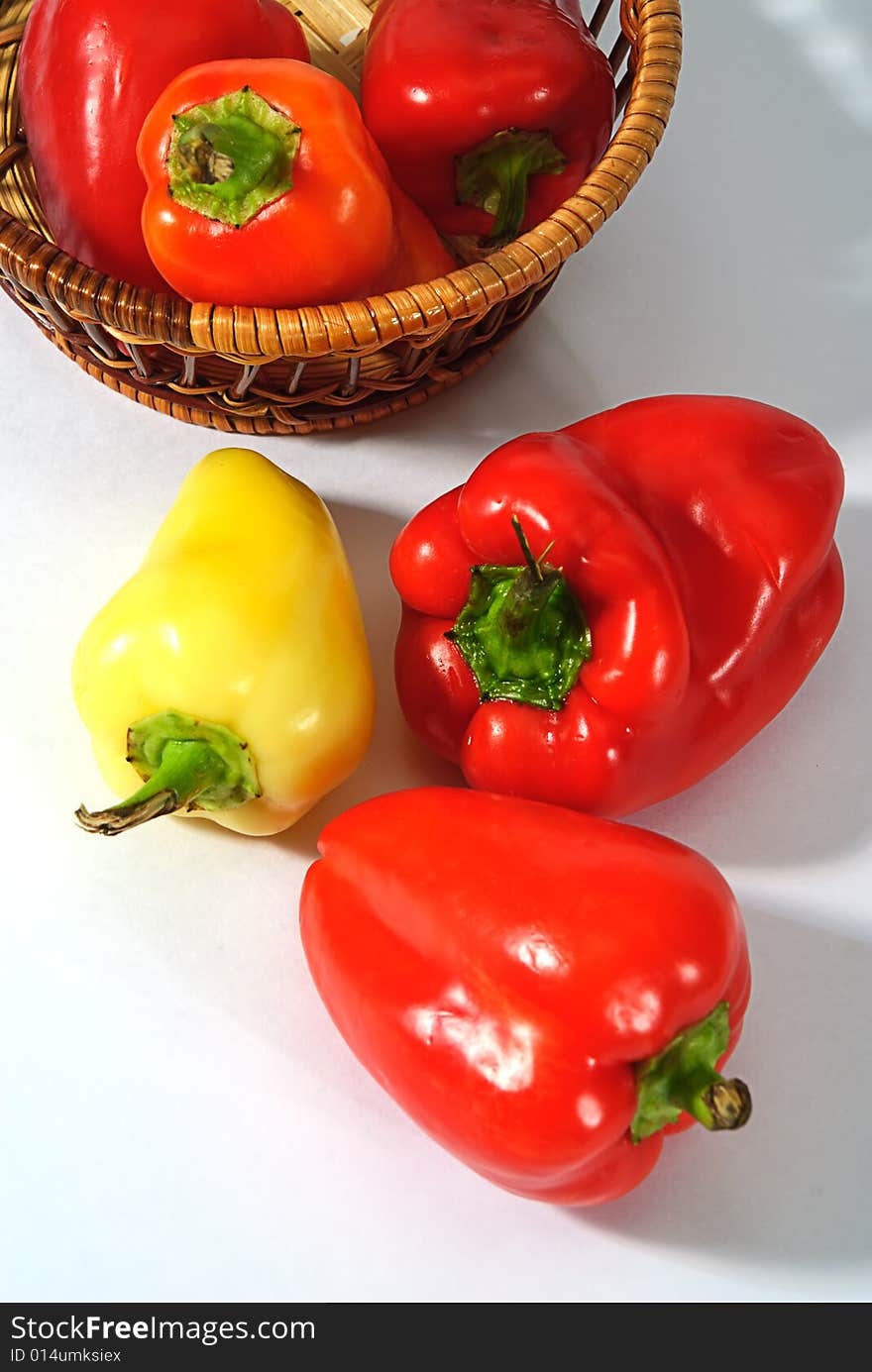 Red and yellow pepper in wooden basket