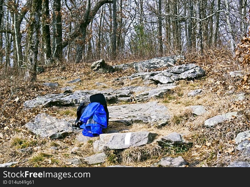 A backpack and jacket lying on the rocks of a trail. A backpack and jacket lying on the rocks of a trail.