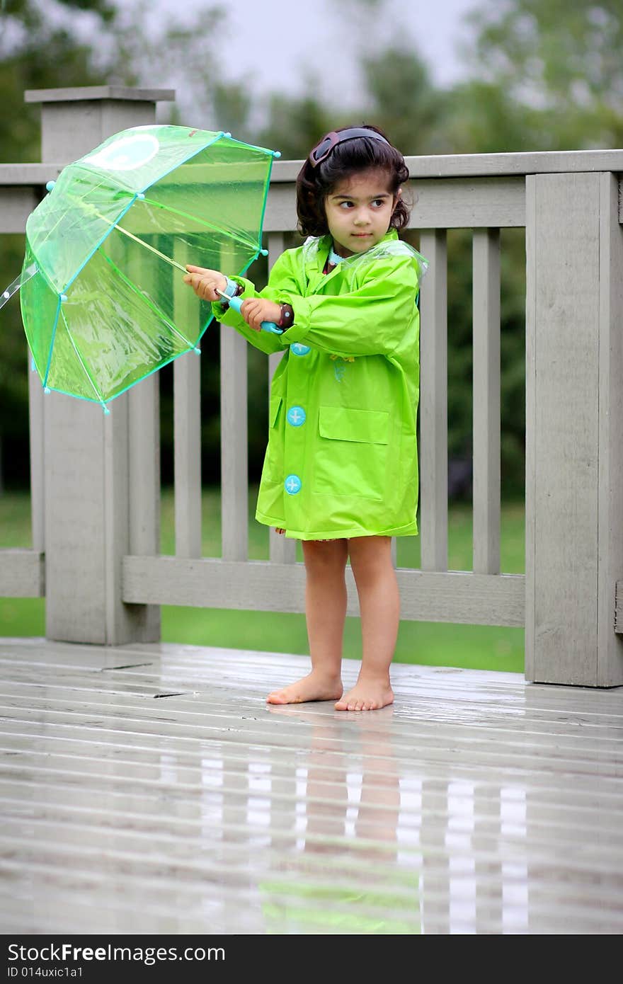 Young girl playing in the rain with rain gears. Young girl playing in the rain with rain gears