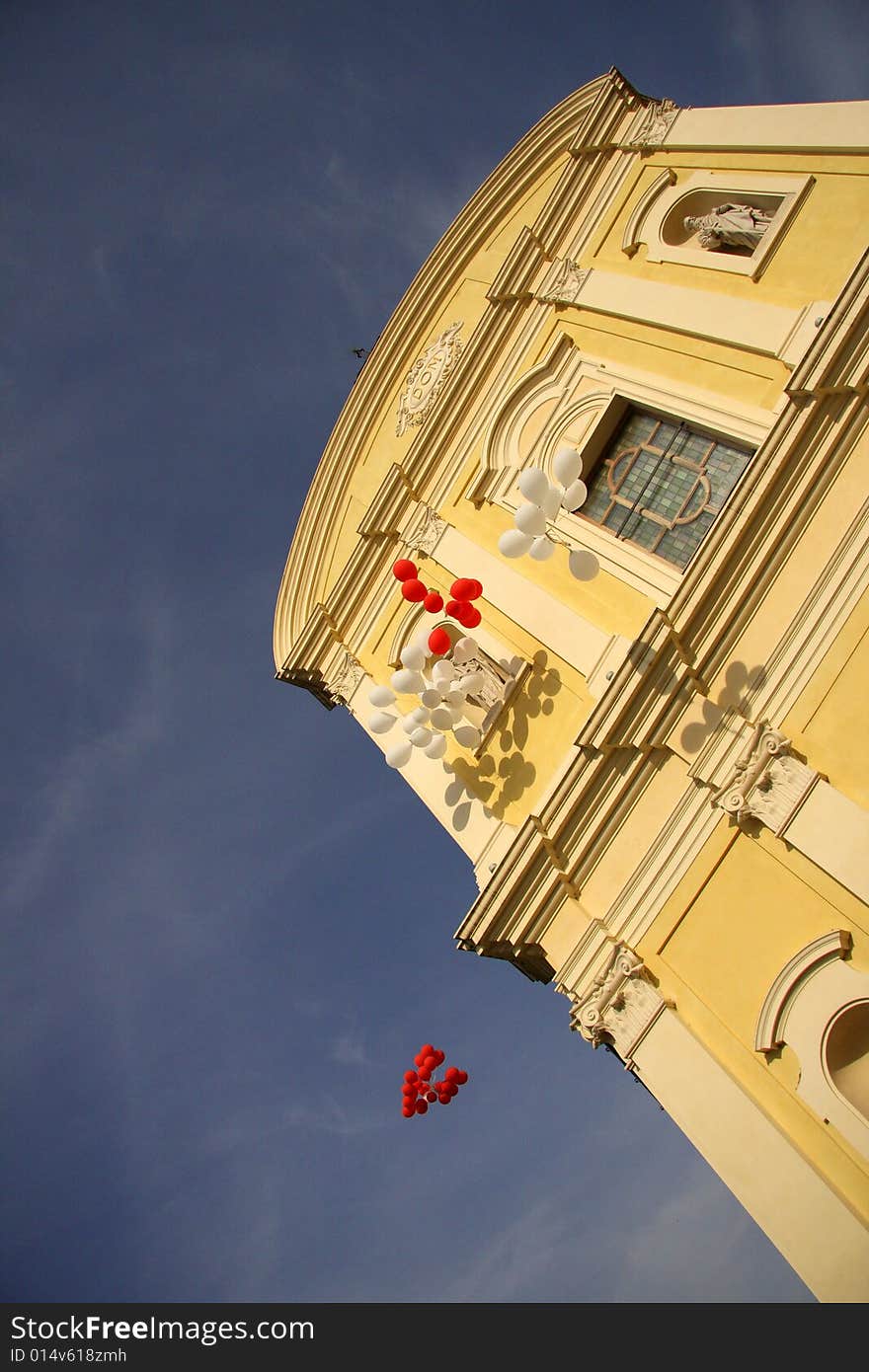 Red and white balloons floating skyward after a wedding