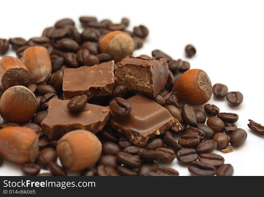 Coffee beans, delicious chocolate and hazel nuts close up. Coffee beans, delicious chocolate and hazel nuts close up