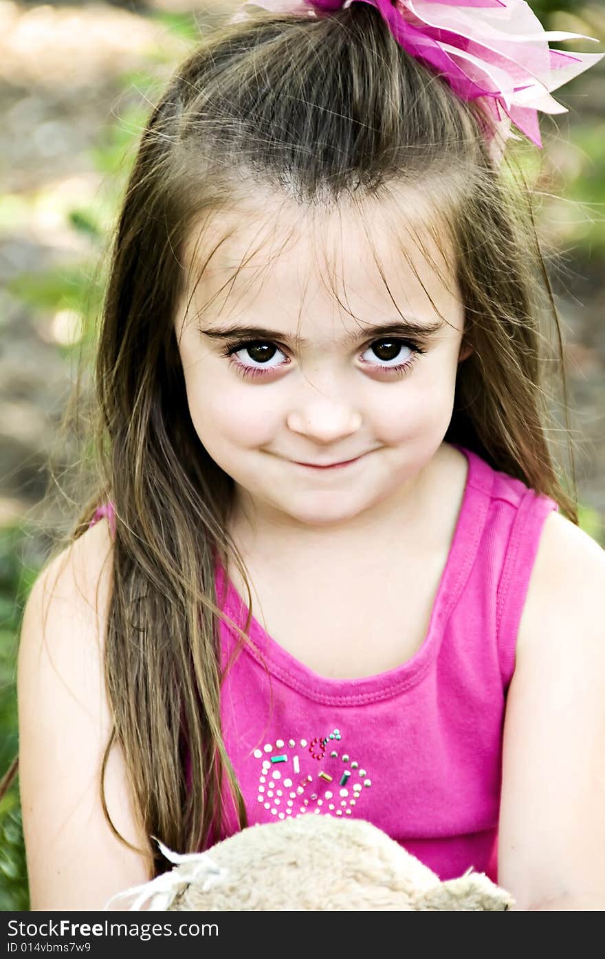 Close-up of a brunette brown eyed little girl wearing a pink shirt. Close-up of a brunette brown eyed little girl wearing a pink shirt