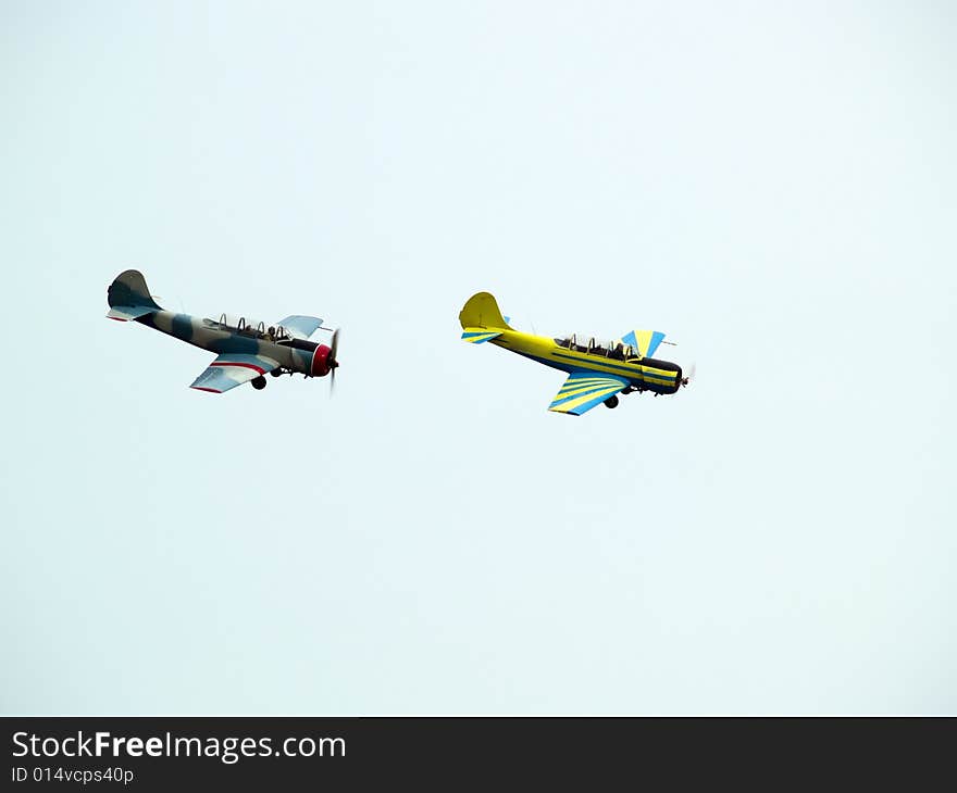 Two small propeller planes performing group aerobatics