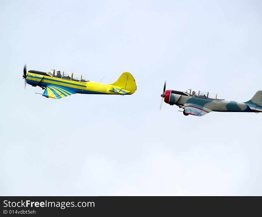 Two small propeller planes performing group aerobatics